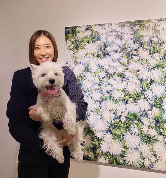 자신의 작품을 배경으로 강아지를 안고 서 있는 허보리 화가 / 허보리 화가 제공