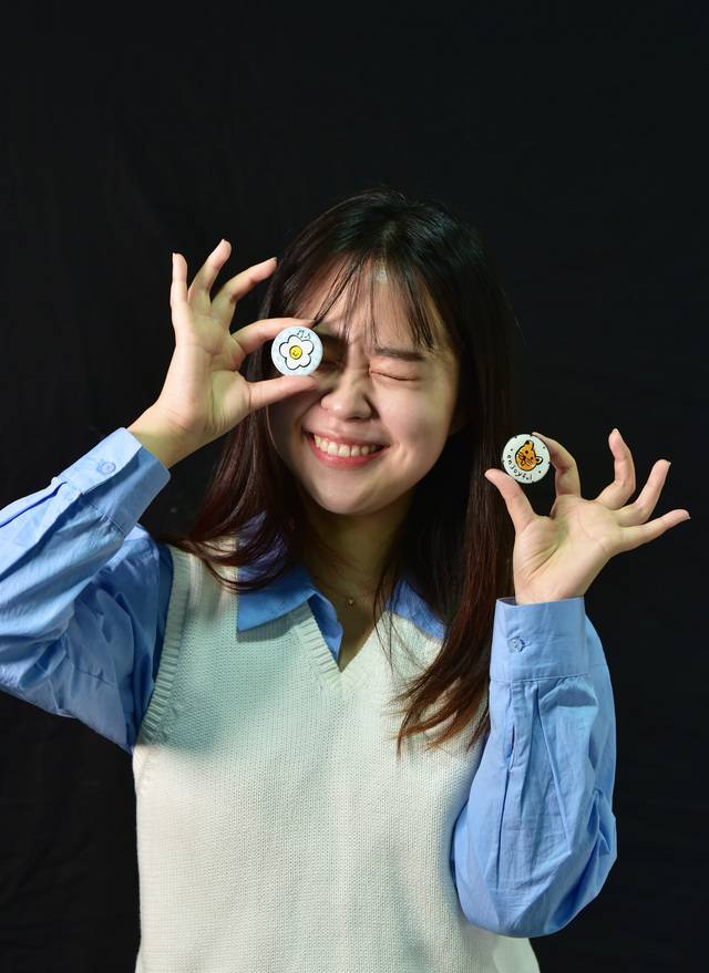 양드림 에이블라인드 대표가 시각장애인 예술가들이 디자인한 스마트폰용 굿즈 제품을 들고 포즈를 취하고 있다.