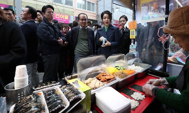 윤석열 대통령 부인 김건희 여사가 3일 경북 포항 죽도시장을 방문해 김밥을 시식한 뒤 구입하고 있다. /뉴시스