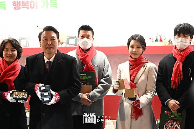 ▲ 윤석열 대통령과 김건희 여사가 12월16일 오후 서울 종로구 열린송현광장에서 열린 윈·윈터 페스티벌 개막식에서 판매 부스를 방문해 물건을 구입하고 있다. 사진=대통령실 홈페이지