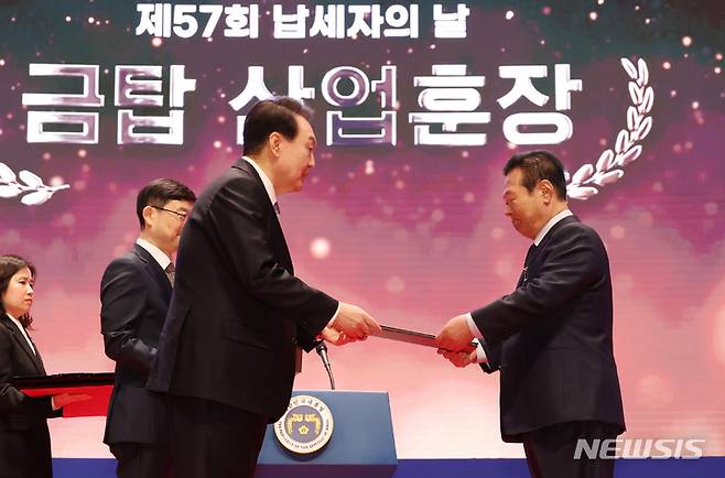 [서울=뉴시스] 홍효식 기자 = 윤석열 대통령이 3일 서울 강남구 코엑스에서 열린 제57회 납세자의 날 기념식에서 이덕한 ㈜쌍곰 대표에게 금탑산업훈장을 수여하고 있다. (대통령실통신사진기자단) 2023.03.03. yesphoto@newsis.com