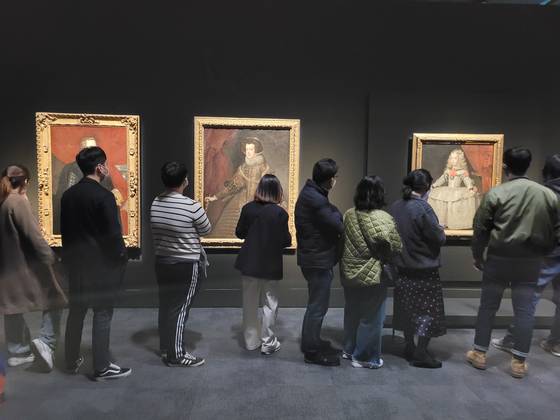 국립중앙박물관 ‘합스부르크 600년, 매혹의 걸작들’ 전시에서 벨라스케스의 ‘흰옷을 입은 마르가리타 테레사 공주’(오른쪽)를 포함한 스페인 왕실 초상화를 보는 관람객들. 문소영 기자