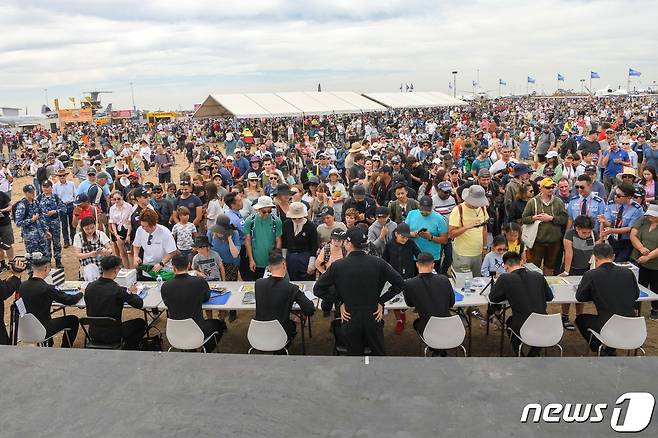 4일(현지시간) 호주 맬버른 애벌론 공항에서 열린 '2023 호주 애벌론 국제에어쇼'에서 대한민국 공군 특수비행팀 블랙이글스(Black Eagles) 조종사들이 기념 사인 행사장을 찾은 관람객들에게 사인과 기념품을 나눠주고 있다. (공군 제공) 2023.3.5/뉴스1