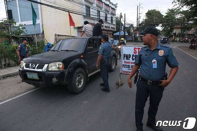 (서울=뉴스1) 정윤영 기자 = 페르디난드 마르코스 필리핀 대통령의 측근인 로엘 데가모 네그로스 오리엔탈주 주지사가 괴한의 총격에 숨진 가운데, 용의자 3명이 붙잡혔다. 사진은 경찰관이 차량을 심문하는 모습. ⓒ AFP=뉴스1 ⓒ News1 정윤영 기자
