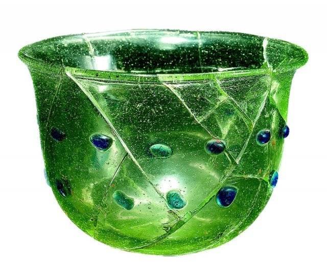 옥전 M1호분에서 출토된 유리잔이다. 옅은 녹색을 띠는 유리그릇으로 표면에는 23개의 남색 점이 표현돼 있다. 동로마에서 제작된 전형적 로만글라스에 해당한다. 입지름 9.7cm, 5세기 중엽.국립진주박물관 제공