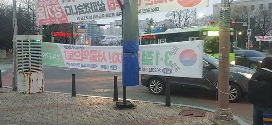 지난달 27일 경남 창원시 성산구 한국은행 사거리 횡단보도 바로 옆에 걸린 정당 현수막. 지면으로부터 1m 높이에 설치돼 있어 우회전 차량이 횡단보도 보행자를 보기 어렵게 가리고 있다. [사진 독자]