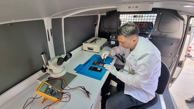 [서울=뉴시스]삼성전자가 튀르키예 지진 피해 지역 주민이 맡긴 휴대폰을 이동 서비스 차량에서 수리하고 있다. (사진 = 삼성전자) 2023.3.9. photo@newsis.com *재판매 및 DB 금지