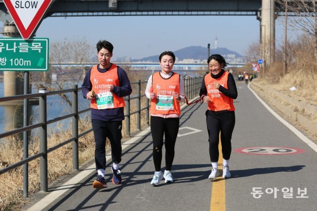 김예지 의원(가운데)이 2월 26일 열린 고구려마라톤 10km에 출전해 ‘가이드 러너’ 홍산 씨(오른쪽)와 함께 달리고 있다. 김예지 의원 제공.