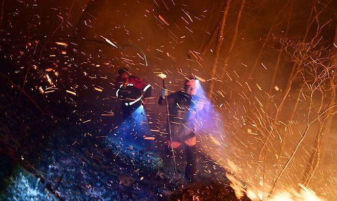 지난 11일 산불진화대원들이 경남 하동군 화개면 대성리에서 진화작업을 벌이다 갑자기 되살아난 산불을 피해 이동하고 있다. 뉴시스