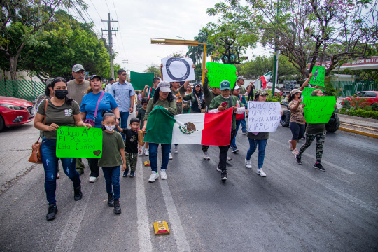 멕시코군을 지지하는 손펫말을 든 군인가족들이 지난 12일(현지시간) 멕시코 치아파스주 툭스틀라 구티에레즈에서 행진하고 있습니다. EPA 연합뉴스
