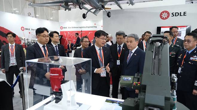 지난달 UAE 방산 전시회에서 이종섭 장관 등 국방부 대표단이 SNT 측으로부터 국산 변속기에 대한 설명을 듣고 있다.