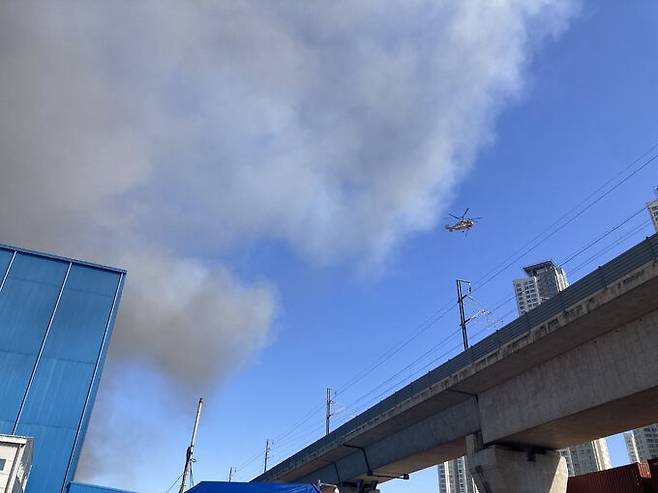 한국타이어 대전공장 화재 발생 11시간여가 지난 13일 오전 9시 헬기가 불을 진압하고 있다. 공장 바로 옆에는 KTX 열차 선로가 있다. 강은선 기자