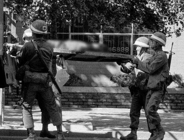 1980년 5월 27일 전남도청을 점령한 계엄군들이 시민의 시신을 트럭에 실으며 묘한 미소를 짓고 있다. 한국일보 자료사진