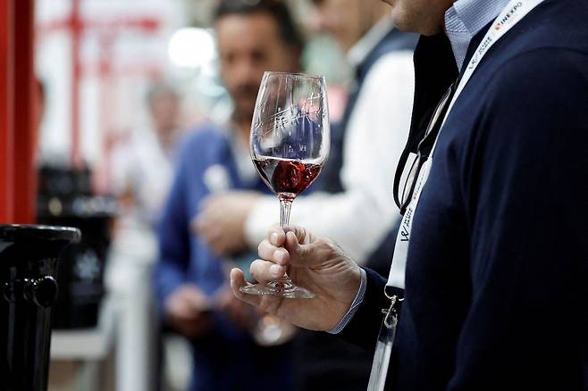 FILE PHOTO: A visitor tastes wine at Wine Paris & Vinexpo at the Paris Expo Porte de Versailles center in Paris, France, February 14, 2022. REUTERS/Benoit Tessier/File Photo