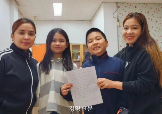 Angela B. Adel (from left) and her Kopino daughter Mihanna Adel Kim, and Dhemin Hackiro Gozum Ahn, a Kopino, and his mother Dandhia Laine G. Gozum hold up a letter thanking Korean citizens for supporting them at the Philadelphia Baptist Church in Cheongju, Chungcheongbuk-do on March 6. Courtesy of Jung Jin-nam, head of the Dream Come True Foundation
