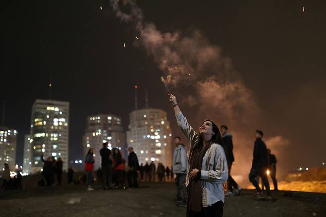 이란 여성이 14일(현지시간) 수도 테헤란의 한 공원에서 이란의 새해맞이 불꽃축제인 '차하르 샴베 수리'를 기념하며 폭죽을 터트리고 있다. 테헤란=로이터연합