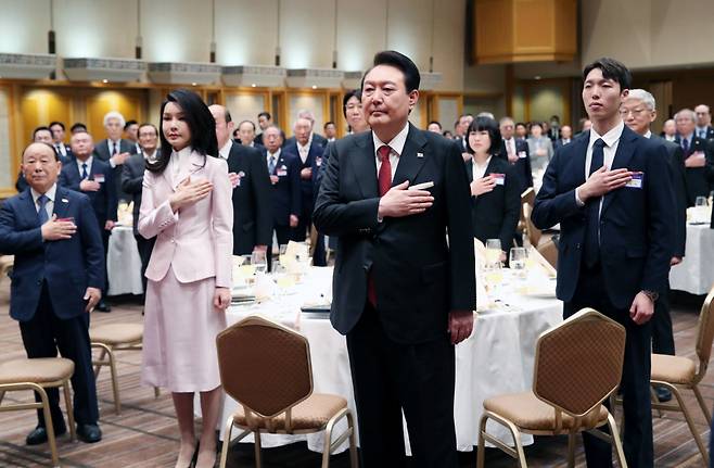 1박2일 간의 일정으로 일본을 방문한 윤석열 대통령과 김건희 여사가 16일 도쿄 한 호텔에서 열린 재일동포 오찬 간담회에서 국기에 경례하고 있다. ⓒ연합뉴스