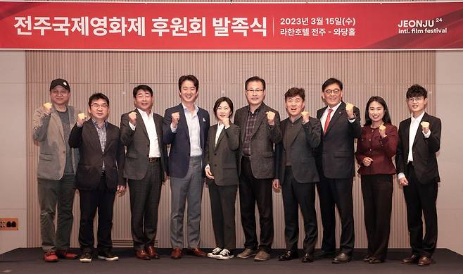 Min Seong-wook (far left) and Jung Jun-ho (fourth from left), co-chairs of the JIFF executive committee, pose with donation committee members in Jeonju, North Jeolla Province, Wednesday. (JIFF)