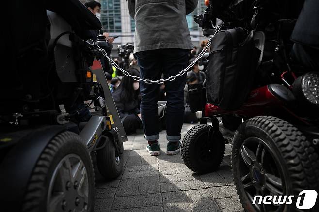 17일 오전 서울 종로구 서울지방경찰청 앞에서 열린 박경석 전국장애인차별철폐연대(전장연) 대표 법원의 체포영장 발부에 따른 입장발표 기자회견에서 참가자들이 쇠사슬로 서로를 잇고 있다. 2023.3.17/뉴스1 ⓒ News1 이승배 기자