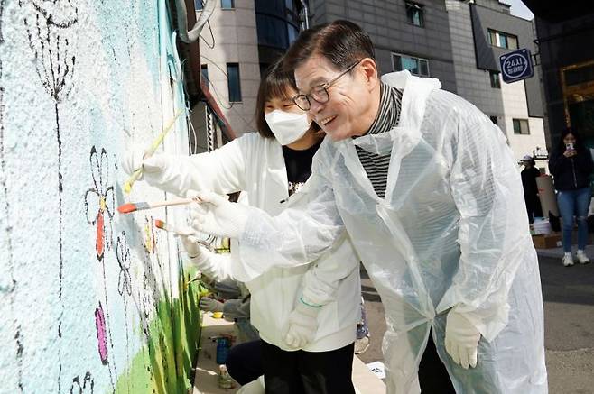 이필형 동대문구청장이 클라랑스 사회공헌활동 대학생 서포터즈 ‘클라미’와 꽃그림을 그리고 있다.