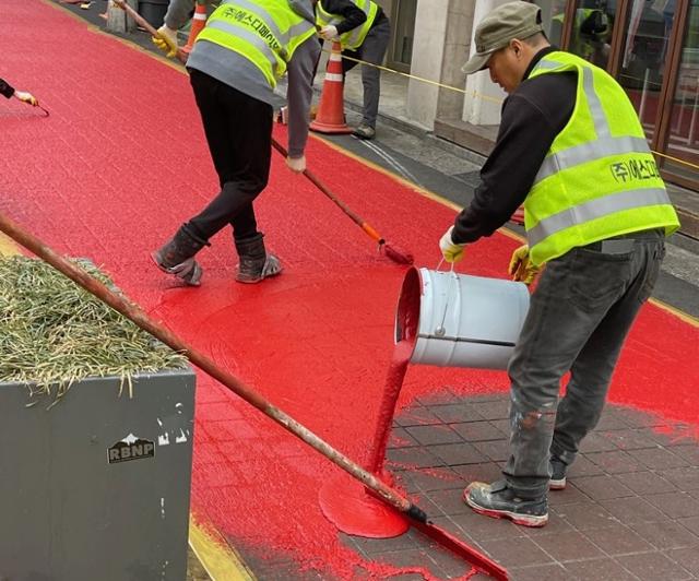 마포구 서교동 홍대 걷고싶은거리 차도에 붉은색 아스팔트콘크리트를 덮는 도포 작업이 진행되고 있다. 독자 제공