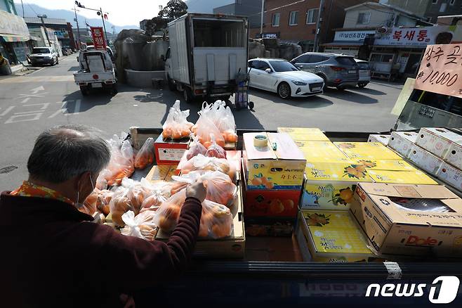 정오가 넘어가자 과일을 팔던 상인이 다른 곳으로 이동하기 위해 물건을 정리해 트럭에 싣고 있다.