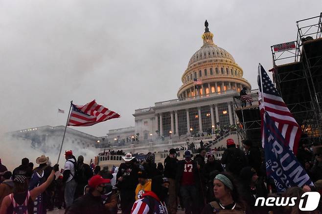 2021년 1월6일(현지시간) 미국 워싱턴DC 의회 앞에서 도널드 트럼프 당시 미국 대통령 지지자들이 바깥으로 모이는 가운데 경찰이 최루탄을 쏘며 해산을 시도하고 있는 모습. ⓒ 로이터=뉴스1 ⓒ News1 김현 특파원