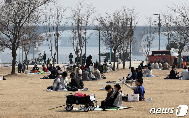 전국이 포근한 날씨를 보인 19일 오후 서울 여의도 한강공원을 찾은 시민들이 돗자리를 펴고 나들이를 즐기고 있다. 2023.3.19/뉴스1 ⓒ News1 구윤성 기자
