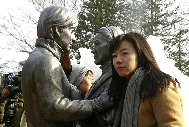 TV드라마 '겨울연가' 촬영지였던 춘천 남이섬에서 2004년 12월 24일 세워진 배용준과 최지우 동상 앞에서 일본인 관광객들이 사진을 찍고 있다. /조선DB
