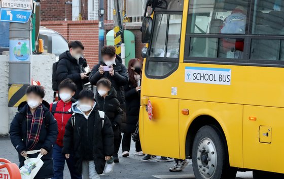 1월 30일 서울 광진구 광장초등학교에서 통학버스를 이용하는 학생들이 마스크를 착용한 채 등교하고 있다. 뉴스1