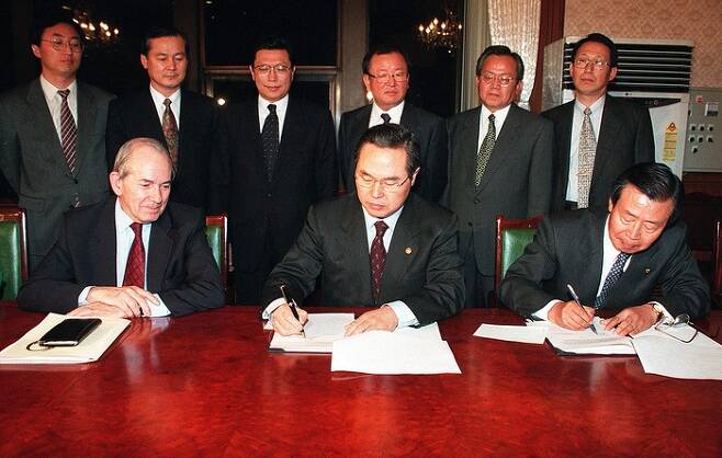 1997년 12월 3일 서울 세종로 정부종합청사에서 임창열 당시 경제부총리(앞줄 가운데)와 이경식 한국은행 총재(오른쪽)가 미셸 캉드쉬 국제통화기금(IMF) 총재(왼쪽)가 지켜보는 가운데 구제금융을 위한 정책이행각서에 서명하고 있다. 경향신문 자료사진