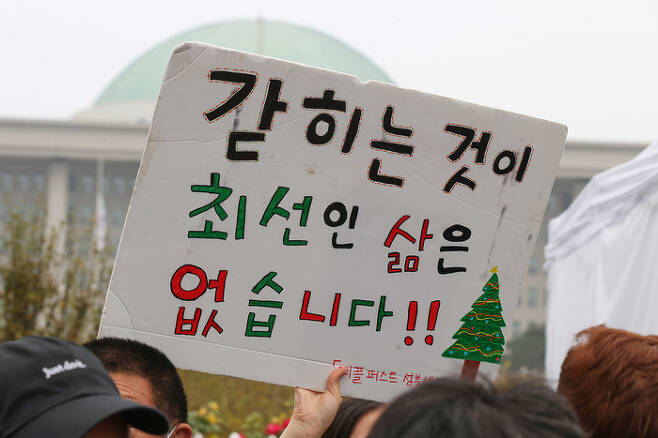 한국피플퍼스트 등 장애인 단체 회원들이 지난해 11월1일 오전 서울 여의도 국회 앞에서 기자회견을 열고 탈시설 과정에서 당사자가 참여할 수 있도록 지원을 촉구하며 손팻말을 들고 있다. 연합뉴스