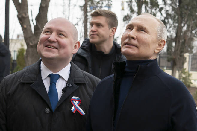 점령지 찾아 보란 듯 웃음 블라디미르 푸틴 러시아 대통령(오른쪽)이 18일(현지시간) 크름반도 세바스토폴 미하일 라즈보차예프 주지사(왼쪽)와 함께 세바스토폴의 린이미술센터를 방문하고 있다. AP연합뉴스