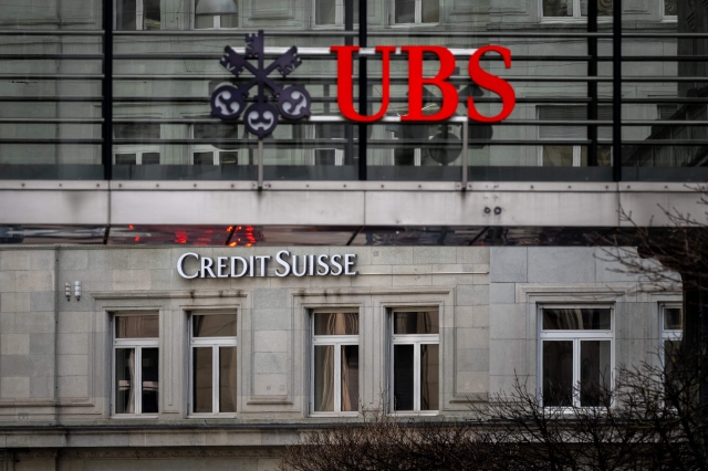 18일(현지시간) 스위스 취리히의 UBS 간판 모습. 뒤에는 크레디스위스의 은행의 간판이 보이고 있다. 영국 일간 파이낸셜타임스(FT)는 이날 UBS가 크레디스위스를 인수하기 위한 협상을 진행 중이라고 보도했다. AFP연합뉴스
