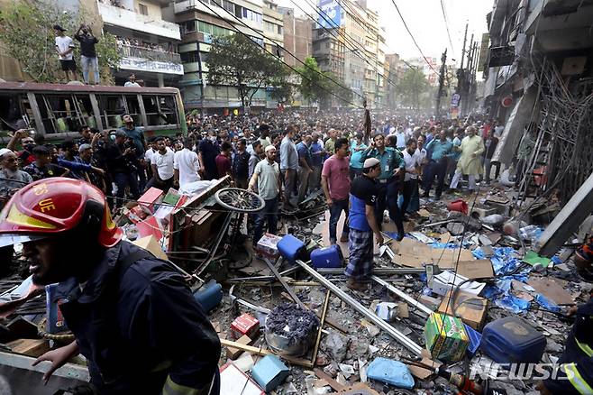 [다카=AP/뉴시스] 3월7일  방글라데시 다카의 건물 폭발 현장에 구경꾼들이 모여 있다. 소방 당국은 7층짜리 상가 건물이 폭발해 최소 18명이 숨지고 120여 명이 다쳤다고 밝혔다. 현지 경찰국장은 "이번 폭발을 사고로 보고 있으며 테러 행위는 아닌 것으로 보인다"라고 밝혔다. 2023.03.08.