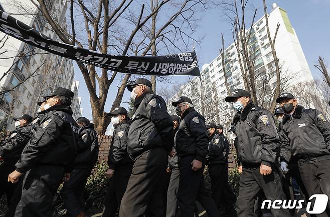 20일 오전 경비원 사망사건이 발생한 서울 강남구 대치동의 한 아파트 앞에서 경비노동자들이 '故 대치동 아파트 경비노동자 추모 기자회견'을 열고 고용불안과 갑질 피해를 규탄하며 행진하고 있다. 2023.3.20/뉴스1 ⓒ News1 김도우 기자