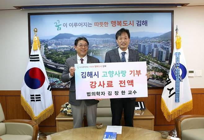 김장한 교수(오른쪽)가 시민교양강좌를 마치고 강사료 전액을 김해시 고향사랑기부금으로 쾌척하고 있다. [사진제공=경남 김해시청]