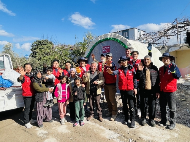 NCMN 왕의기업이 최근 튀르키예 오스마니예주에서 지진으로 가족과 터전을 잃은 가정을 방문해 임시로 거주할 텐트를 설치한 뒤 함께 사진을 찍고 있다. NCMN 제공
