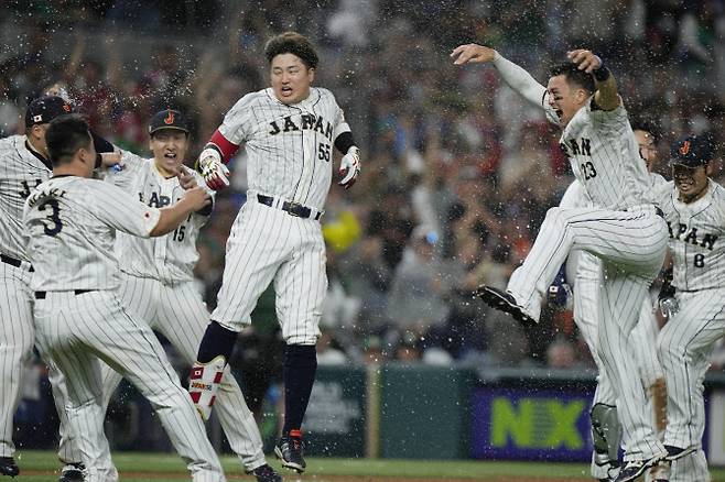 일본 야구대표팀 무라카미 무네타카(가운데)가 극적인 끝내기 결승타를 때린 뒤 동료들과 함께 기뻐하고 있다. 사진=AP PHOTO