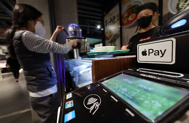 20일 서울 시내의 한 음식점에 애플의 간편결제 서비스 ‘애플페이’ 스티커가 붙은 결제 단말기가 놓여있다. 애플은 21일 국내에서 애플페이를 출시한다. 이날부터 아이폰에 신용카드 정보를 등록한 이용자들은 NFC 결제 단말기가 있는 매장에서 실물 카드 없이도 결제할 수 있다./연합뉴스