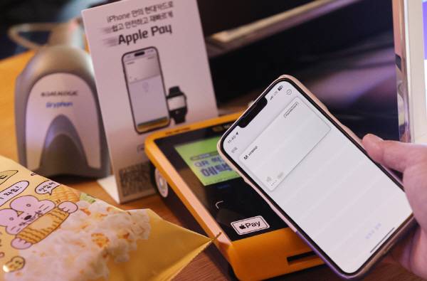애플의 간편결제 서비스 ‘애플페이’ 서비스 개시일인 21일 서울 용산구 이마트24 R한남제일점에서 한 시민이 애플페이로 상품을 결제하고 있다. 연합뉴스