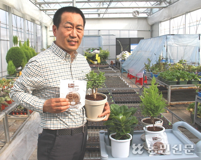 압축배양토를 개발한 김대균 경기도농업기술원 연구사가 압축배양토 ‘토비’와 이를 사용한 화분을 들고 설명하고 있다.