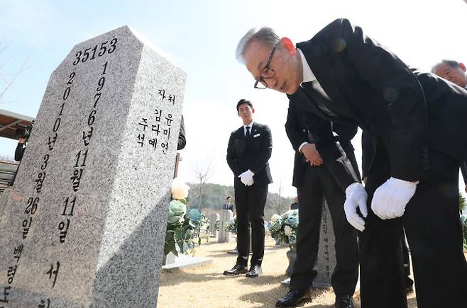 이명박 전 대통령이 22일 대전시 유성구 국립대전현충원 천안함 46용사 묘역을 참배한 뒤 묘비를 살펴보고 있다.(사진=뉴시스)