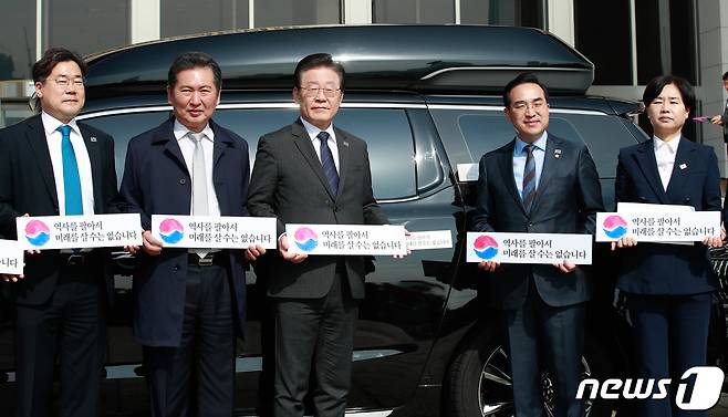 이재명 더불어민주당 대표를 비롯한 지도부가 22일 서울 여의도 국회에서 대일굴종외교 규탄 태극기달기 운동 행사의 일환으로 차량에 태극마크와 '역사를 팔아서 미래를 살 수는 없습니다'라고 적힌 스티커를 부착한 뒤 기념 촬영하고 있다. 2023.3.22/뉴스1 ⓒ News1 안은나 기자