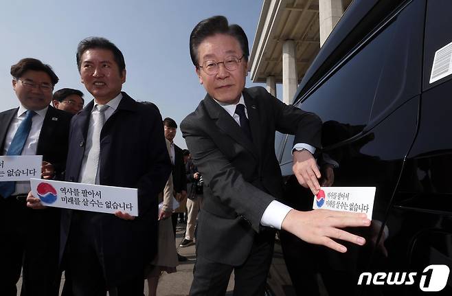 이재명 더불어민주당 대표가 22일 서울 여의도 국회에서 대일굴종외교 규탄 태극기달기 운동 행사의 일환으로 차량에 태극마크와 '역사를 팔아서 미래를 살 수는 없습니다'라고 적힌 스티커를 부착하고 있다. (공동취재) 2023.3.22/뉴스1 ⓒ News1 안은나 기자