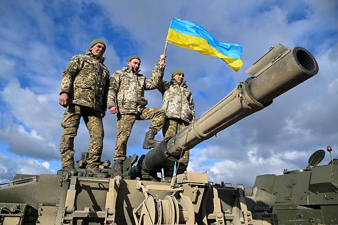 지난 2월22일 영국 남서부의 보빙턴 훈련 캠프에서 영국군이 우크라이나에 제공하는 주력 전차인 챌린저 2 탱크에 대한 훈련을 받고 있는 우크라이나 포병들이 우크라이나 국기를 흔들고 있다./로이터 연합뉴스