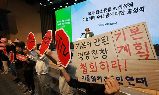 기후위기비상행동을 비롯한 환경단체 회원들이 22일 서울 강남구 한국과학기술회관에서 열린 탄소중립녹색성장위원회와 환경부의 '국가 탄소중립 녹색성장 기본계획 정부안' 첫 공청회에 참석해 김상협 탄소중립녹색성장위원회 민간위원장의 인사말 때 기습 손팻말·펼침막 시위를 벌이고 있다. 연합뉴스