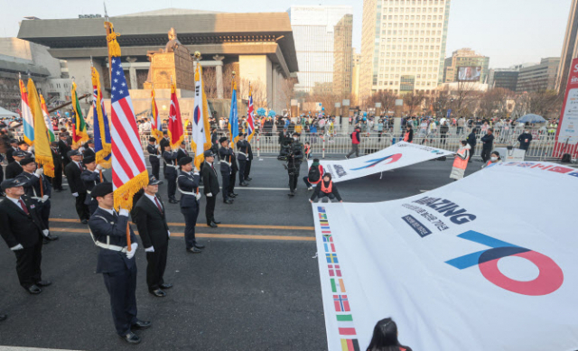 이달 19일 6·25전쟁 참전 용사들과 학군사관 후보생들이 광화문광장에서 열린 ‘2023 서울 마라톤’에서 참전국의 깃발을 들고 도열해 있다. 연합뉴스
