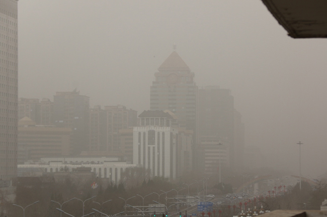 22일 오전 중국 베이징에 황사 황색경보가 내려진 가운데 베이징 시내 주요 건물이 황사로 인해 형체가 흐릿하게 보인다. [사진 제공 = 연합뉴스]
