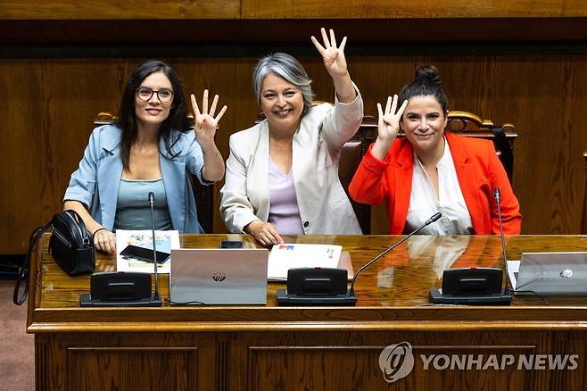 칠레 근로 시간 주당 40시간으로 단축법안 상원 통과 (발파라이소[칠레] EPA=연합뉴스) 히아네트 하라 노동부 장관(가운데)이 21일(현지시간) 칠레 상원 본회의장에서 근로 시간 단축 법안 통과 이후 안토니아 오레예나 여성 및 성평등부 장관(오른쪽), 카밀라 바예호 정부 대변인(왼쪽)과 기념 촬영하고 있다. 2023.3.23 [칠레 상원 제공. 재판매 및 DB 금지]